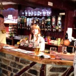 Kath behind the bar serving two customers